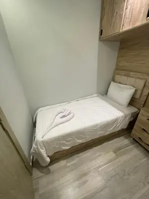 a small bed in a small room with white sheets at New Marina Apartments in Hurghada