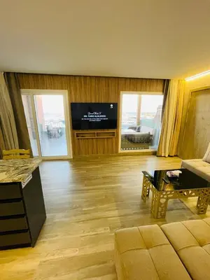 a living room with a television and a couch and a table at New Marina Apartments in Hurghada