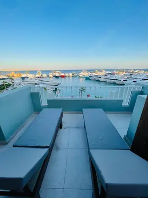a balcony with benches and a view of a harbor at New Marina Apartments in Hurghada