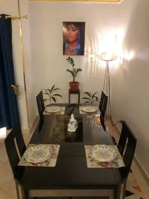 a dining room table with two chairs and a lamp at New Marina Apartments in Hurghada