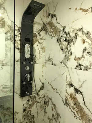 a bathroom with a marble wall with a clock on it at New Marina Apartments in Hurghada
