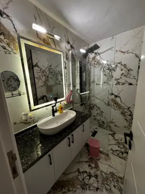 a bathroom with a sink and a marble wall at New Marina Apartments in Hurghada