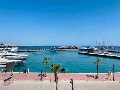 a marina with palm trees and boats in the water at New Marina Deluxe in Hurghada