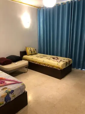 two beds in a room with blue curtains at New Marina Deluxe in Hurghada
