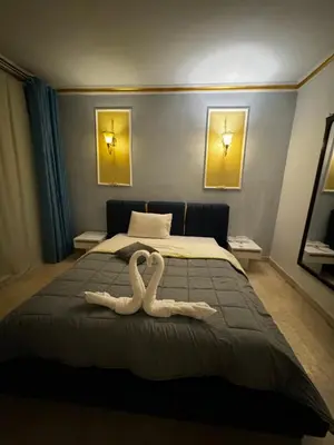 two swans towels on a bed in a bedroom at New Marina Deluxe in Hurghada