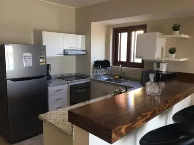a kitchen with a refrigerator and a counter top at Sabina Comfort Residence in Hurghada