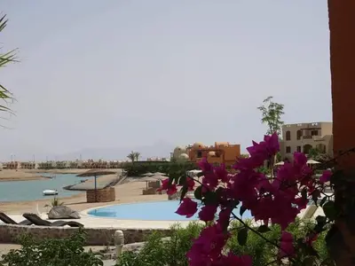 a resort with a swimming pool and purple flowers at Sabina Comfort Residence in Hurghada