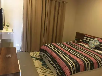 a bedroom with a bed and a table and a window at Sabina Comfort Residence in Hurghada