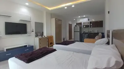 a bedroom with two beds and a flat screen tv at Mirage bay aquapark and resort 110 C minaland in Hurghada