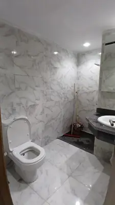 a white bathroom with a toilet and a sink at Mirage bay aquapark and resort 110 C minaland in Hurghada