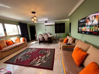 a living room with couches and a large screen at Large Nile View apartment 2 Rooms Air-con Downtown in Aswan
