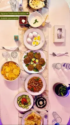 a table with many plates of food on it at Large Nile View apartment 2 Rooms Air-con Downtown in Aswan
