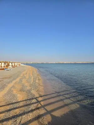 a sandy beach with water and houses on it at Ferienwohnung Sahl Hasheesh in Hurghada