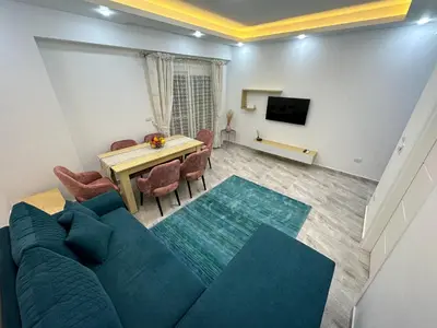 a living room with a blue couch and a table at Luxurious Apartment in Selena Bay - Private Beach, 5 Pools and Kite Surfing in Hurghada