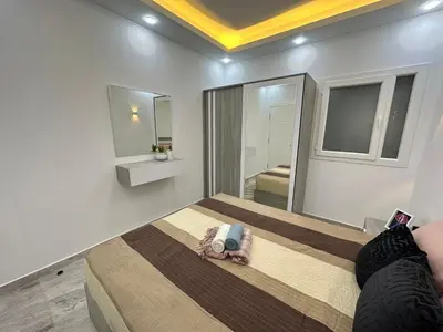 a bedroom with a bed and a large mirror at Luxurious Apartment in Selena Bay - Private Beach, 5 Pools and Kite Surfing in Hurghada
