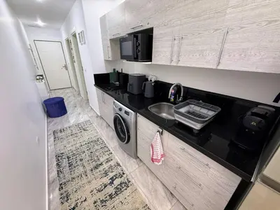 a small kitchen with a sink and a microwave at Luxurious Apartment in Selena Bay - Private Beach, 5 Pools and Kite Surfing in Hurghada