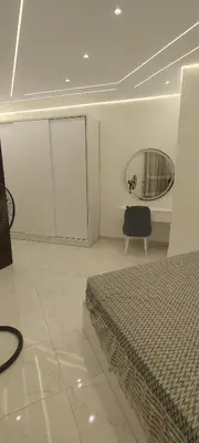 a bedroom with a bed and a mirror and a chair at Juliana Beach Resort Hurghada D402 in Hurghada