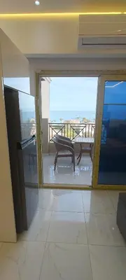 a room with a balcony with a view of the ocean at Juliana Beach Resort Hurghada D402 in Hurghada