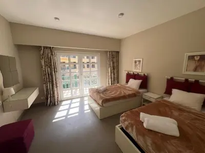 a hotel room with two beds and a window at Elegant 2BR Apartment • Ocean View Abu Tig Marina in Hurghada