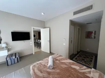 a bedroom with a bed and a flat screen tv at Elegant 2BR Apartment • Ocean View Abu Tig Marina in Hurghada