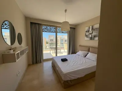 a bedroom with a bed and a large window at 3 Bdr Sea View with private roof Mangrovy EL Guna in Hurghada