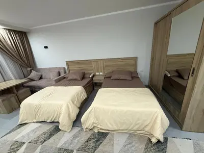 a bedroom with two beds and a couch at Scandic resort in Hurghada