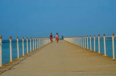 two people walking on a pier over the water at Scandic resort in Hurghada