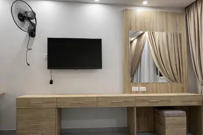 a television on a wall with a mirror and a fan at Scandic resort in Hurghada