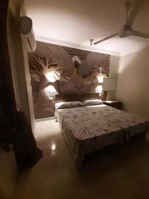 a bedroom with a bed with a painting on the wall at Horus Heights in Idfu