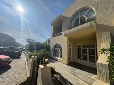 a building with cars parked in a parking lot at 4 Bedroom Seaside Hurghada Escape in Hurghada