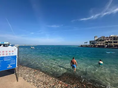 a man and woman walking in the water at the beach at 4 Bedroom Seaside Hurghada Escape in Hurghada