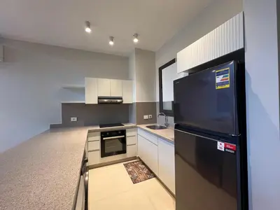 a kitchen with a black refrigerator and white cabinets at Bohemian-Style 3BR Townhouse in Shedwan, El Gouna. in Hurghada