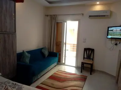 a living room with a blue couch and a tv at Casablanca Beach Appartment in Hurghada