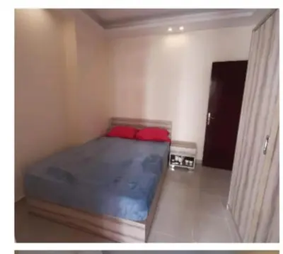 a bedroom with a bed with red pillows in it at Casablanca Beach Appartment in Hurghada