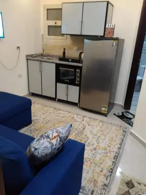 a living room with a blue couch and a kitchen at Casablanca Beach Appartment in Hurghada