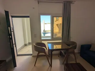 a living room with a glass table and two chairs at Magawish Studio 2 with Pool in Hurghada