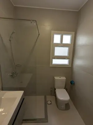 a bathroom with a toilet and a shower and a window at Magawish Studio 2 with Pool in Hurghada