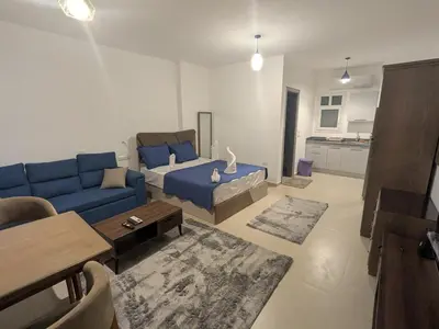 a living room with a blue couch and a table at Magawish Studio 2 with Pool in Hurghada