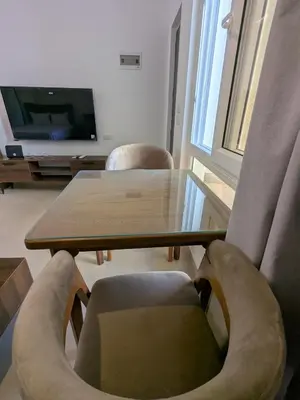 a living room with a table and chairs and a tv at Magawish Studio 2 with Pool in Hurghada
