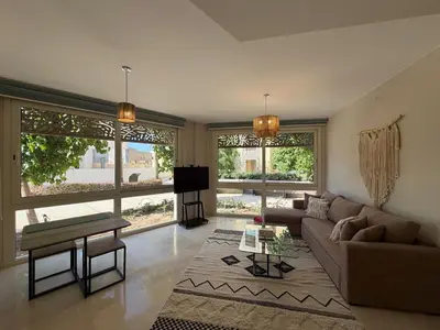 a living room with a couch and a tv at Cozy 1BR GF Mangroovy Residence in Hurghada