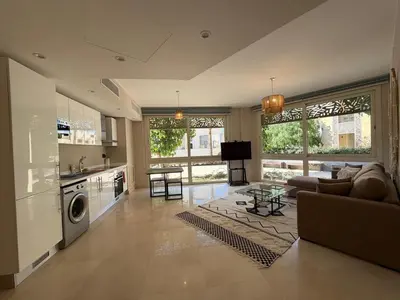 a large living room with a couch and a kitchen at Cozy 1BR GF Mangroovy Residence in Hurghada