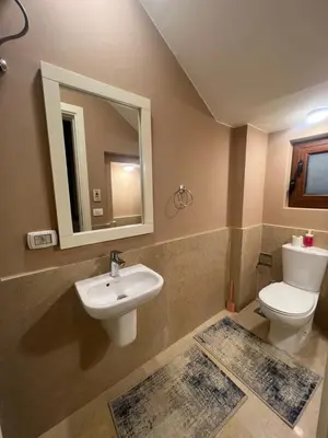 a bathroom with a sink and a toilet and a mirror at Exclusive Villa in Sabina • 4 BR • Private Pool in Hurghada
