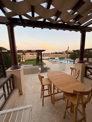 a wooden table and chairs on a patio at Exclusive Villa in Sabina • 4 BR • Private Pool in Hurghada