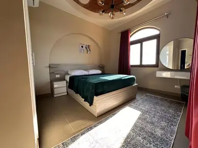 a bedroom with a bed and a window and a mirror at Exclusive Villa in Sabina • 4 BR • Private Pool in Hurghada