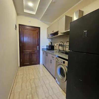 a kitchen with a black refrigerator and a washing machine at Hurghada 201 in Hurghada