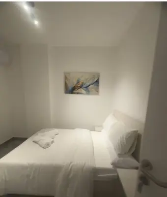 a white bedroom with a bed and a chair at 422batthepavillionImperialHurghada in Hurghada