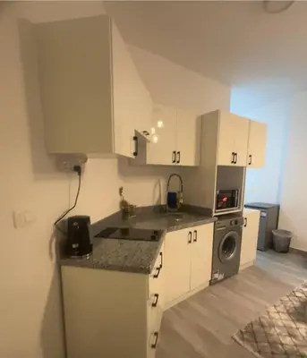 a kitchen with white cabinets and a washer and dryer at 422batthepavillionImperialHurghada in Hurghada