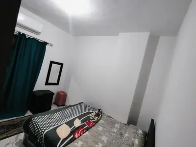 a bedroom with a bed and a green curtain at Turtles Beach Chalet in Hurghada