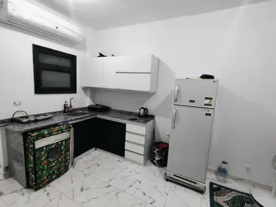 a small kitchen with a refrigerator and a sink at Turtles Beach Chalet in Hurghada