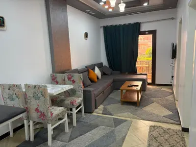 a living room with a couch and a table and chairs at Modern 1BR Seaside Apartment C1 in Turtles Beach in Hurghada